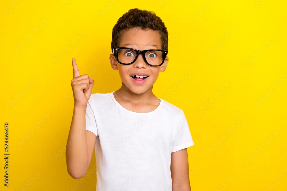 Photo of cute boy raise arm hand wear stylish outfit spectacles find solution problem answer question isolated on yellow color background